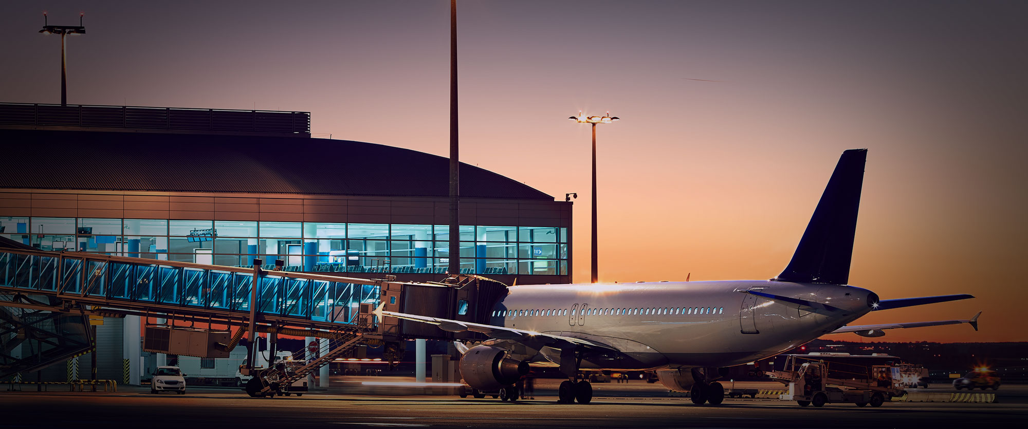 Airliner at an airport gate at sunset