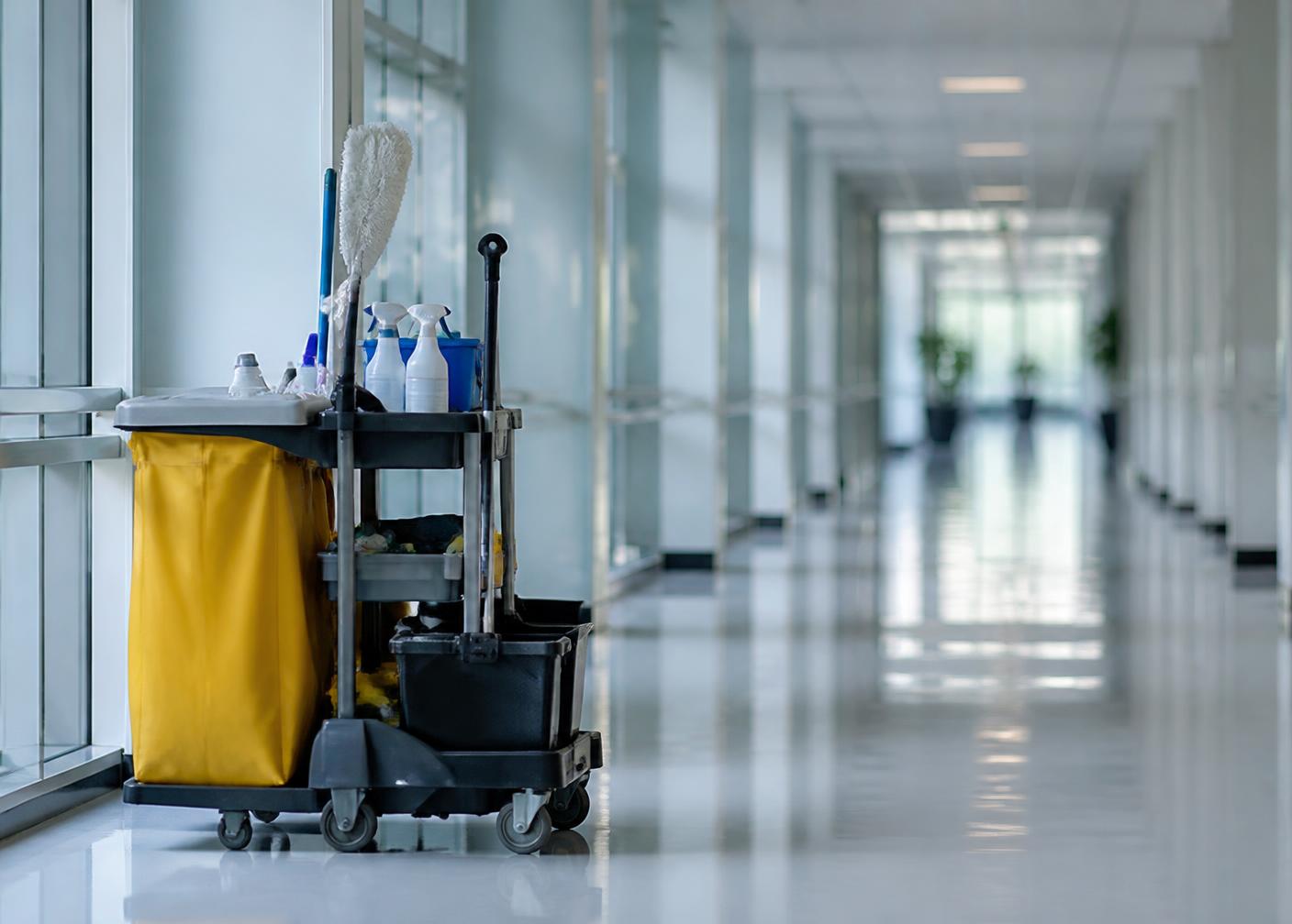Cleaning cart in a bright empty hospital corridor with reflective floors